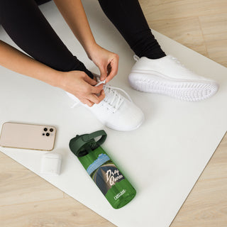 Drag Queen Camelbak water bottle in green placed beside workout shoes, phone, and AirPods.