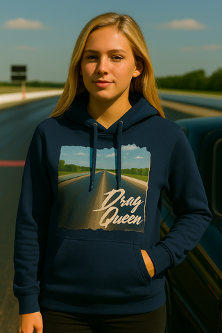 A young woman with long blonde hair stands outdoors on a sunny day wearing a navy blue hoodie with a 'Drag Queen' drag strip graphic on the front. The hoodie features wide flat drawstrings and a front pocket, styled in a casual automotive-themed look.